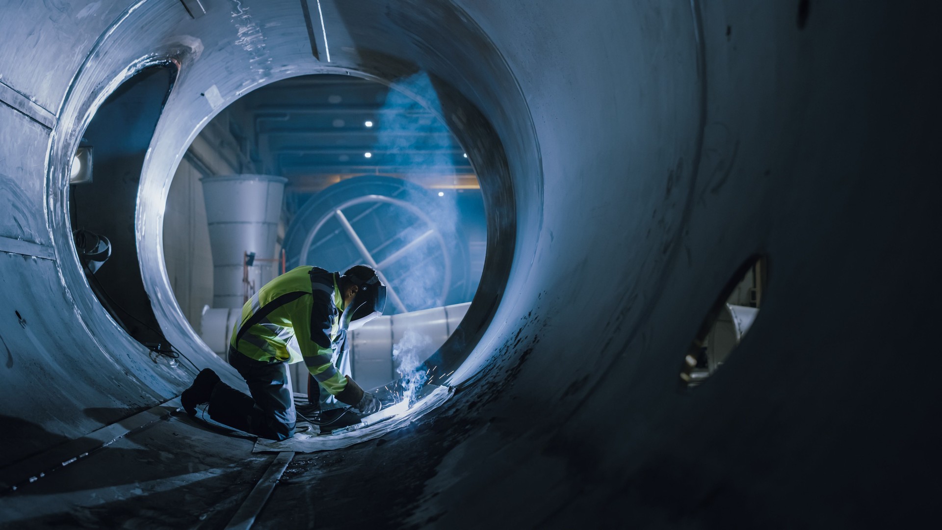 Soldador profesional de la industria pesada que trabaja dentro de la tubería, usa el casco y comienza a soldar. Construcción del Gasoducto de Transporte de Petróleo, Gas Natural y Combustibles. Fábrica de Fabricación Industrial